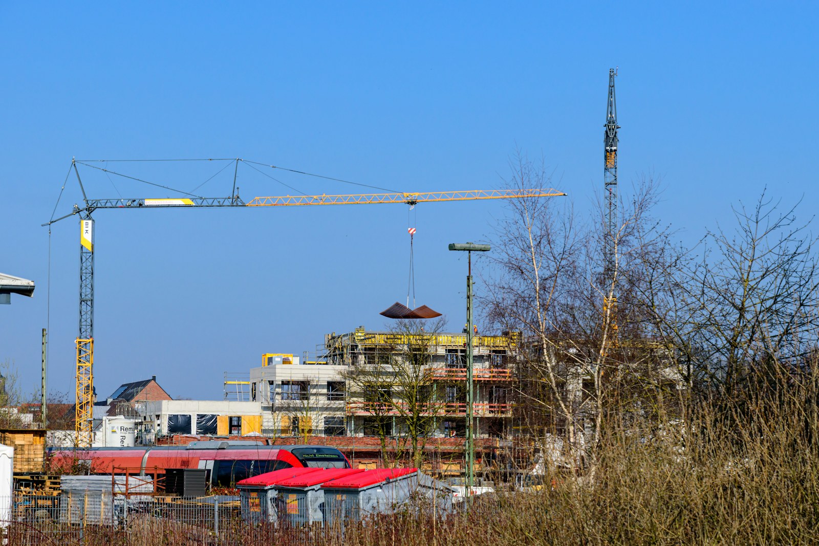 Construction cranes above a generic industrial building site.