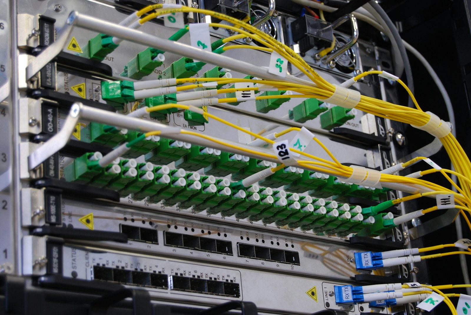 Yellow fibre-optic cables connected in a telecommunications rack.
